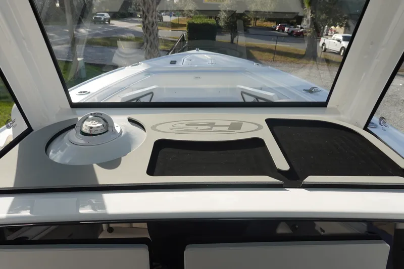 Slide: The Image of 2026 Sea Hunt Ultra 275 SE dashboard with compass and logo, viewed from inside. - 18
