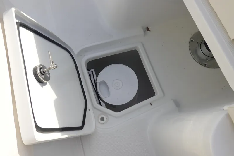 Slide: The Image of 2026 Sea Hunt Ultra 275 SE storage compartment with open hatch and secure latch. - 24