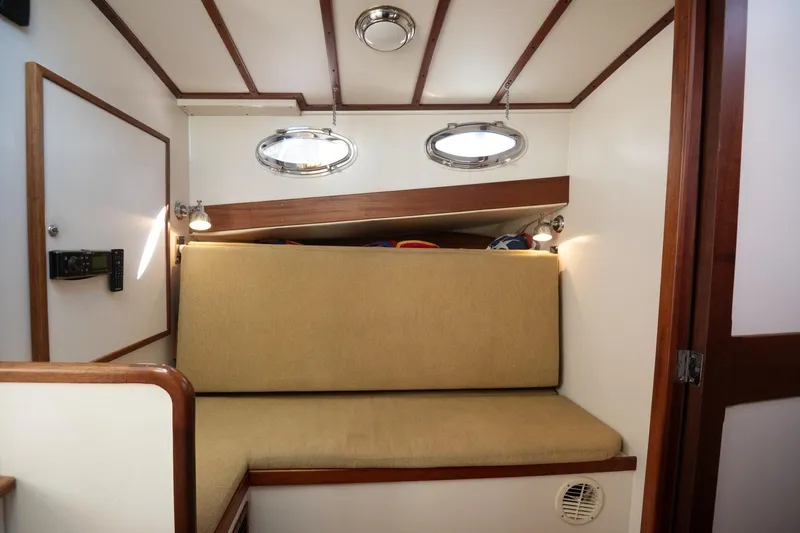 Slide: The Image of Cozy cabin interior of 2005 Mast & Mallet Thomas Point boat with beige seating. - 21