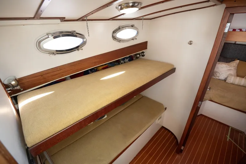 Slide: The Image of 2005 Mast & Mallet Thomas Point boat interior with bunk beds and portholes. - 22
