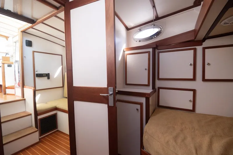 Slide: The Image of Interior of 2005 Mast & Mallet Thomas Point boat, featuring wood accents and cozy cabin space. - 25