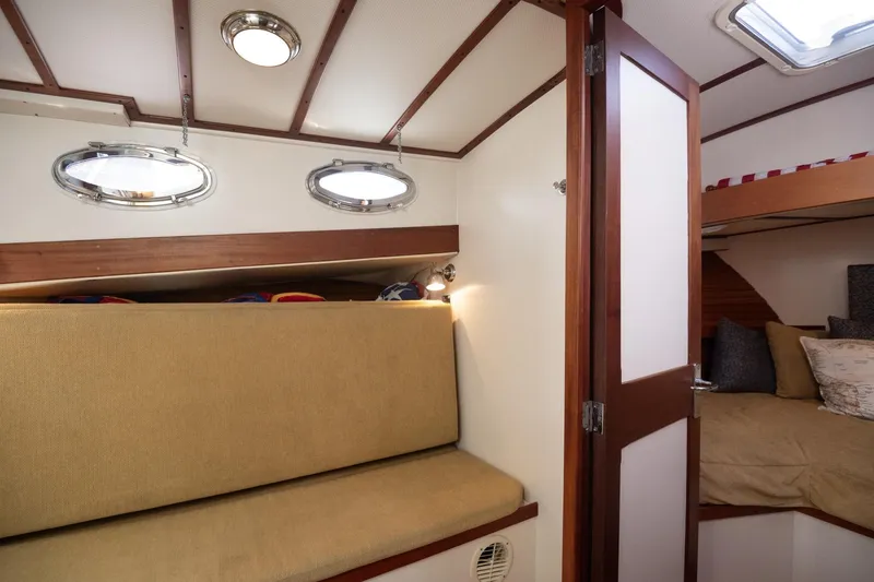 Slide: The Image of Interior of 2005 Mast & Mallet Thomas Point boat with cozy seating and portholes. - 26