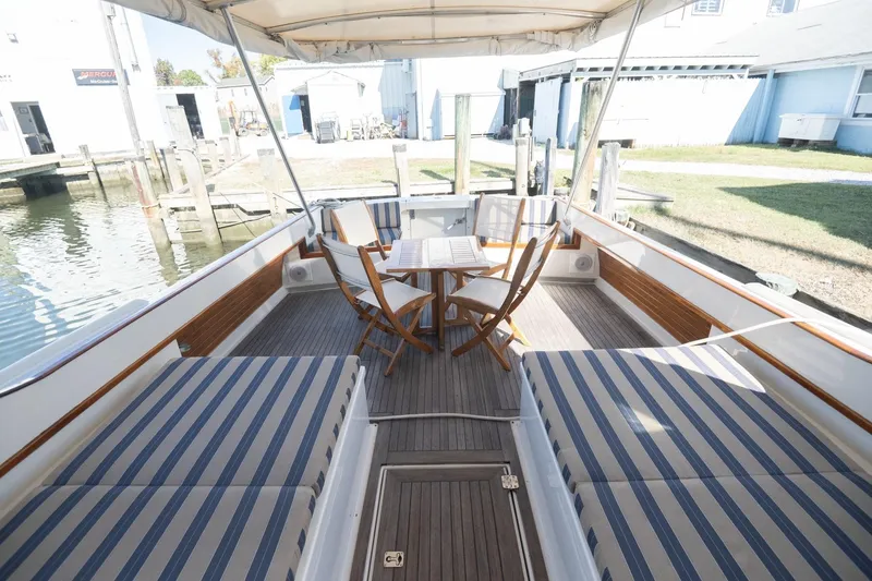 Slide: The Image of 2005 Mast & Mallet Thomas Point boat interior with striped seating and wooden table. - 36