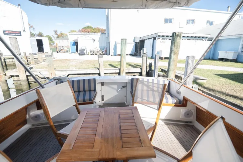 Slide: The Image of 2005 Mast & Mallet Thomas Point boat interior with wooden table and striped seating. - 5
