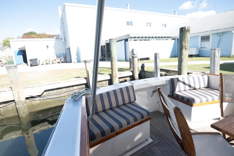 Slide: The Image of 2005 Mast & Mallet Thomas Point boat interior with striped seating at dock. - 6