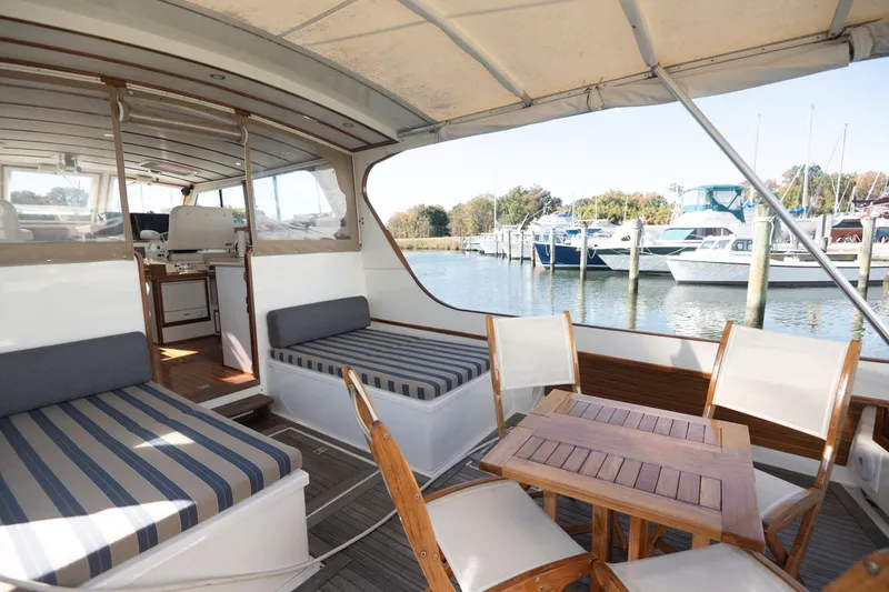 Slide: The Image of Spacious 2005 Mast & Mallet Thomas Point boat interior with striped seating and wooden table. - 7