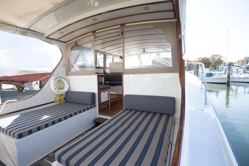 Slide: The Image of 2005 Mast & Mallet Thomas Point boat interior with striped seating and life preserver. - 8