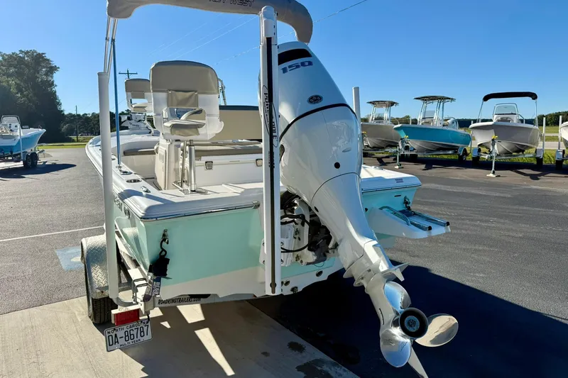 Slide: The Image of 2023 Key West 188 Bay Reef boat with outboard motor in a parking lot. - 36