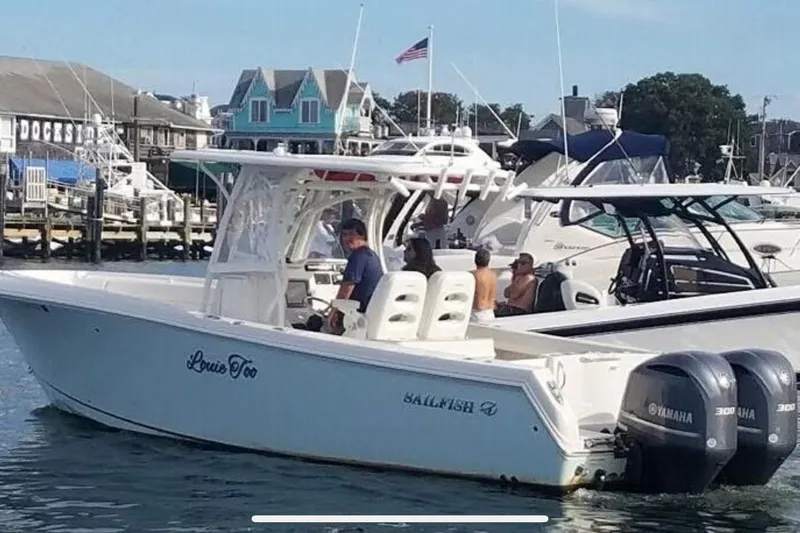 The Image of 2015 Sailfish 290 CC boat with twin Yamaha engines docked in a marina. - 0