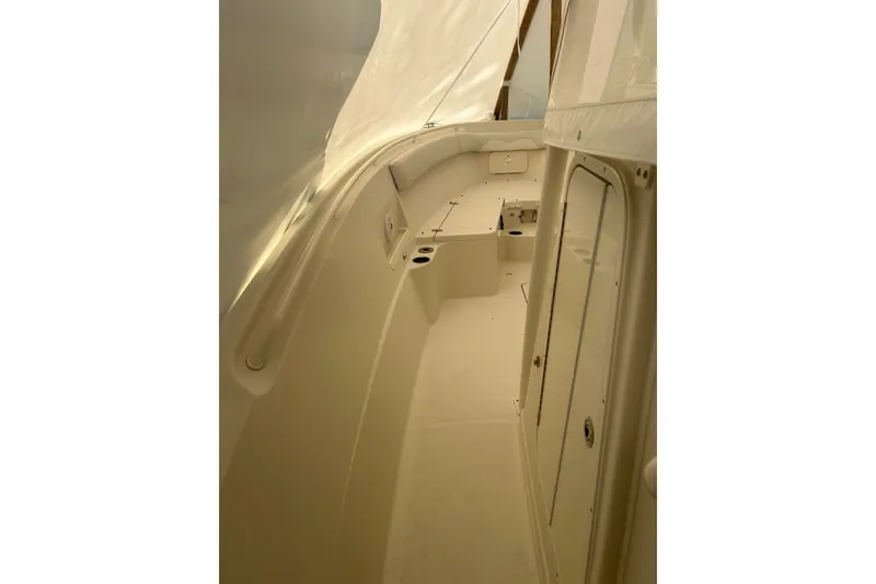 Slide: The Image of 2015 Sailfish 290 CC boat interior with storage compartments and mini fridge. - 12