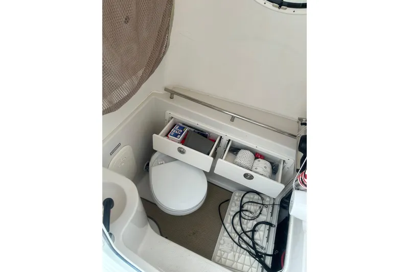 Slide: The Image of 2015 Sailfish 290 CC boat interior with compact bathroom and storage. - 16