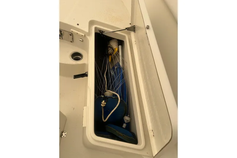 Slide: The Image of Open storage compartment on 2015 Sailfish 290 CC boat with ropes and gear. - 23