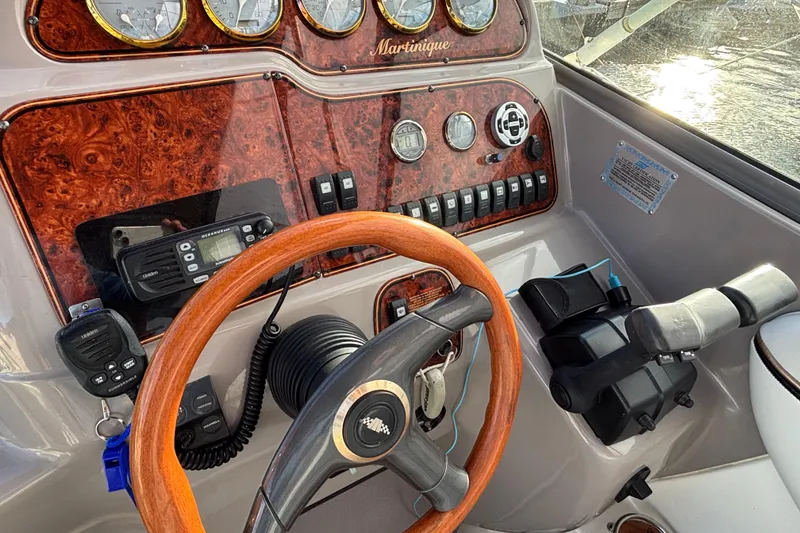 Slide: The Image of 2001 Wellcraft 2800 Martinique boat dashboard with wood steering wheel and control panel. - 13