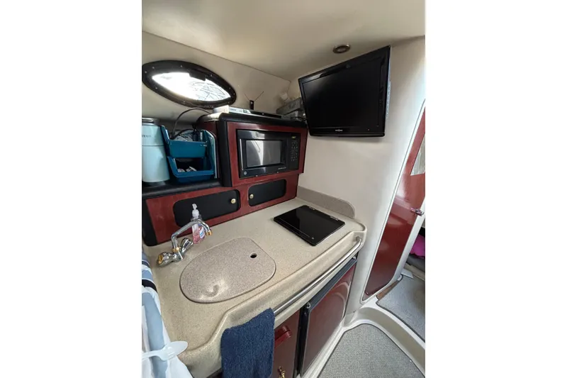 Slide: The Image of 2001 Wellcraft 2800 Martinique cabin interior with curved seating and wooden table. - 18