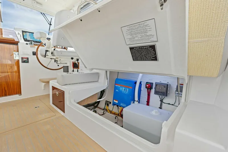 Slide: The Image of 2025 MJM 35 boat interior showing helm and storage compartment with electrical components. - 32