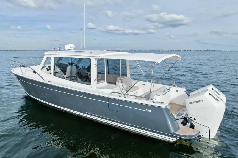 Slide: The Image of 2025 MJM 35 boat on calm water with Mercury outboard engine. - 42