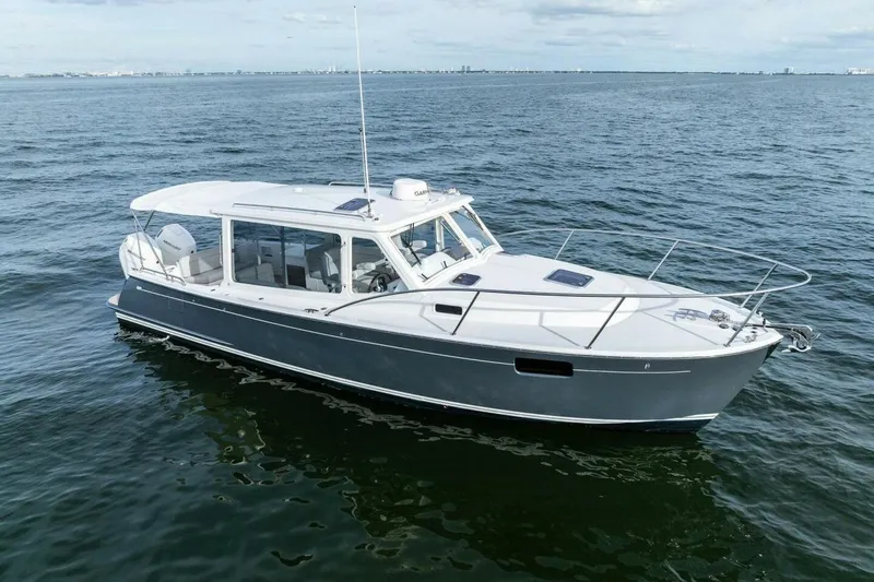 Slide: The Image of 2025 MJM 35 boat cruising on open water under a clear sky. - 45