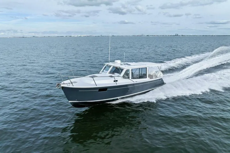 Slide: The Image of 2025 MJM 35 boat cruising on open water under a cloudy sky. - 48