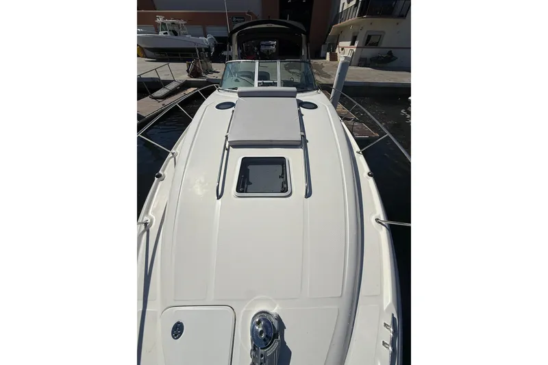 Slide: The Image of 2003 Sea Ray 320 Sundancer boat docked, showcasing sleek deck design. - 11