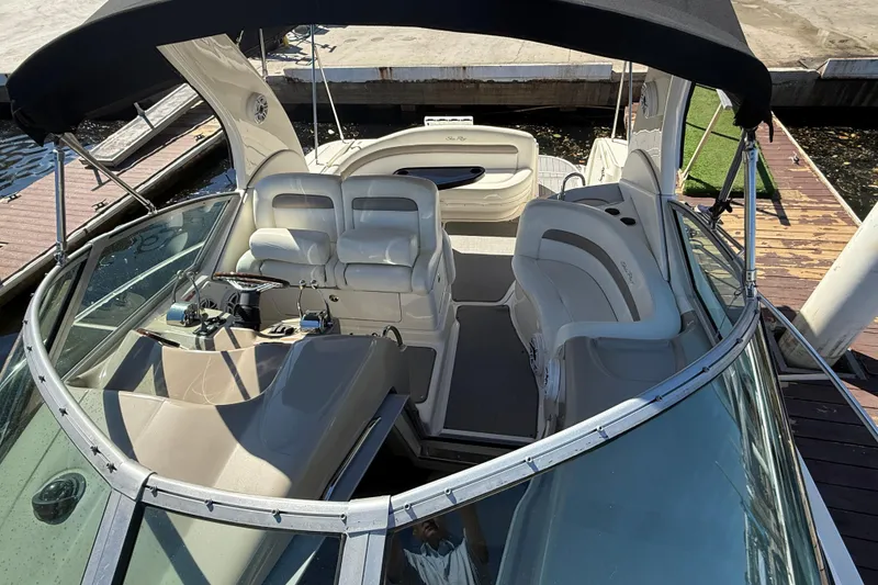 Slide: The Image of 2003 Sea Ray 320 Sundancer boat interior with seating and helm, docked at marina. - 13