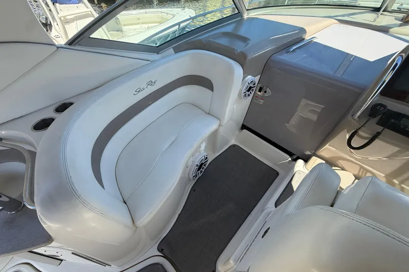 Slide: The Image of 2003 Sea Ray 320 Sundancer cockpit with white seating and control panel. - 21