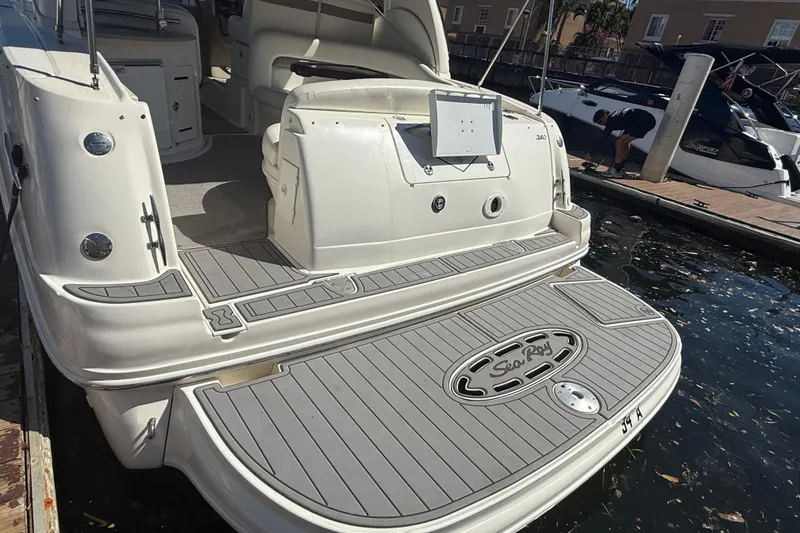 Slide: The Image of 2003 Sea Ray 320 Sundancer yacht docked, showcasing spacious rear deck and elegant design. - 25