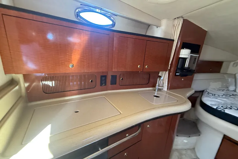 Slide: The Image of 2003 Sea Ray 320 Sundancer interior with kitchenette and sleeping area. - 29