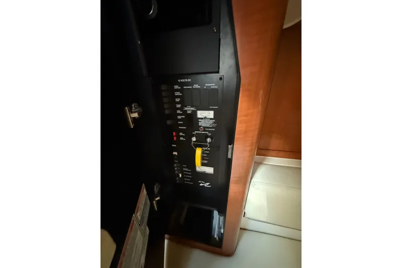 Slide: The Image of Electrical panel inside 2003 Sea Ray 320 Sundancer boat, featuring various switches and controls. - 32