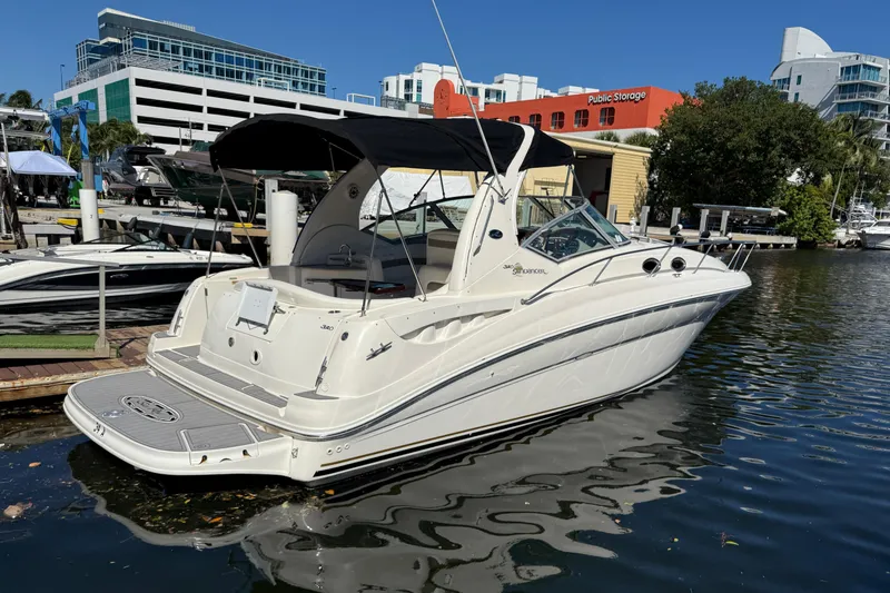 Slide: The Image of 2003 Sea Ray 320 Sundancer boat docked in a marina, under clear blue skies. - 5