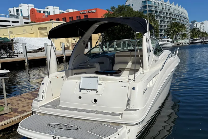 Slide: The Image of 2003 Sea Ray 320 Sundancer docked at marina, featuring sleek design and spacious deck. - 6