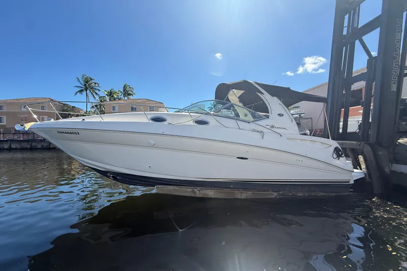 Slide: The Image of 2003 Sea Ray 320 Sundancer boat lifted from water, sunny day, palm trees in background. - 8