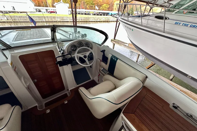 Slide: The Image of 2003 Chris-Craft Corsair 25 boat interior with steering wheel and seating area. - 10