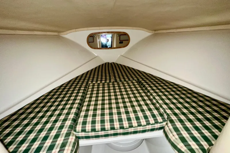Slide: The Image of 2003 Chris-Craft Corsair 25 cabin interior with plaid cushions and compact design. - 12