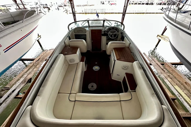 Slide: The Image of 2003 Chris-Craft Corsair 25 boat interior with white seating and wooden accents. - 5