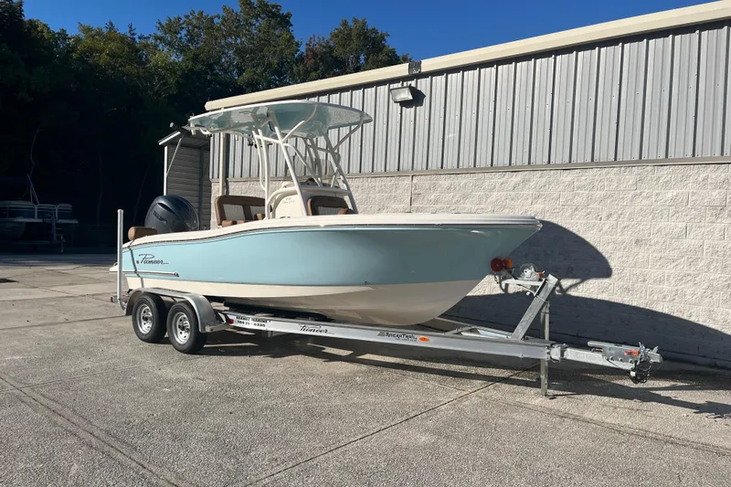 The Image of 2026 Pioneer 202 Sportfish boat on trailer, parked outdoors near a building. - 1