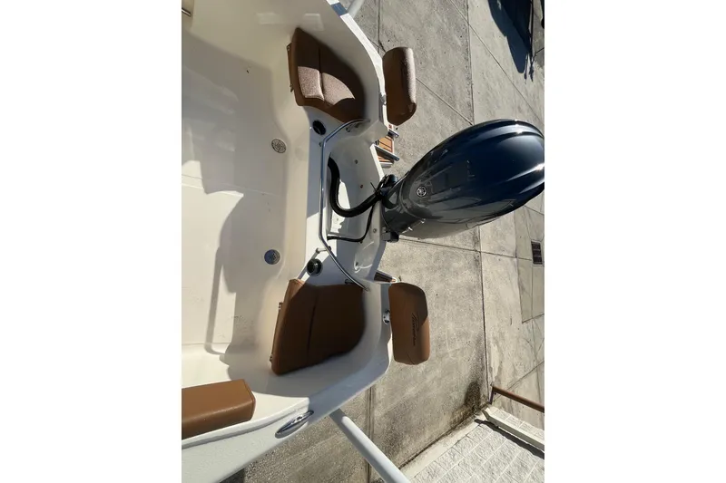 Slide: The Image of 2026 Pioneer 202 Sportfish boat with brown seating and outboard motor. - 12