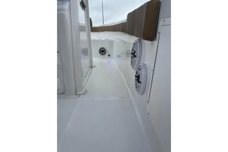 Slide: The Image of 2023 Sea Hunt Ultra 305 SE boat interior with speakers and cushioned seating. - 14