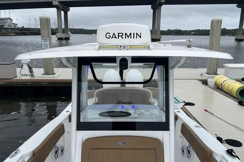 Slide: The Image of 2023 Sea Hunt Ultra 305 SE boat docked, featuring Garmin equipment and spacious seating. - 17
