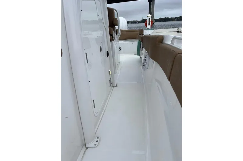 Slide: The Image of 2023 Sea Hunt Ultra 305 SE boat interior with white deck and brown seating. - 22