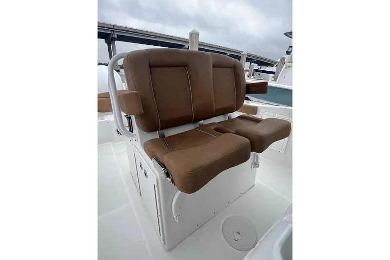 Slide: The Image of 2023 Sea Hunt Ultra 305 SE boat seating with brown cushions, white base, and armrests. - 28
