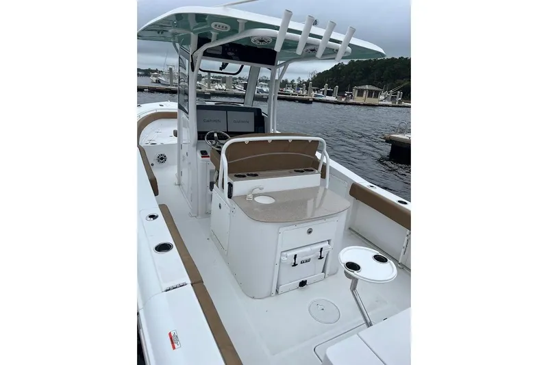 Slide: The Image of 2023 Sea Hunt Ultra 305 SE boat interior with helm, seating, and Garmin displays at a marina. - 32
