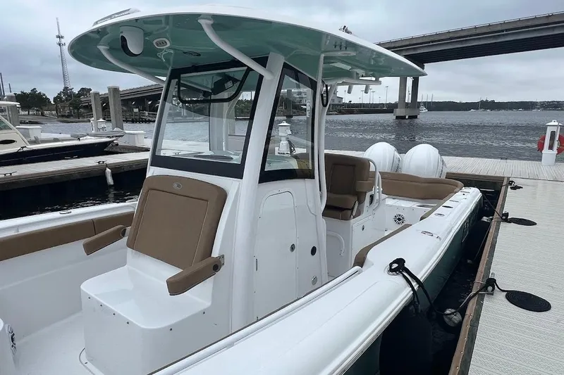 Slide: The Image of 2023 Sea Hunt Ultra 305 SE boat docked by the waterfront, showcasing sleek design. - 34