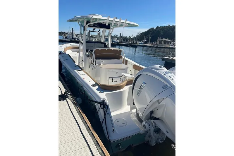 Slide: The Image of 2023 Sea Hunt Ultra 305 SE boat interior with seating and storage, docked by the water. - 8