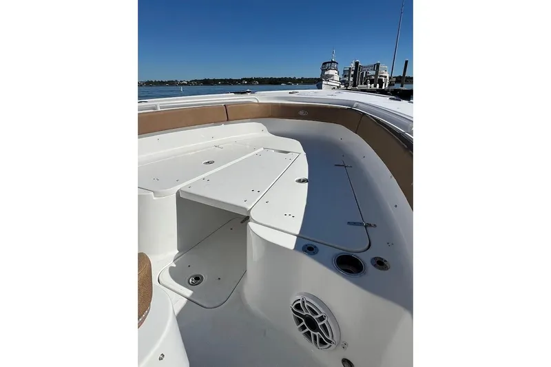 Slide: The Image of 2023 Sea Hunt Ultra 305 SE boat interior with brown seating and white paneling. - 9