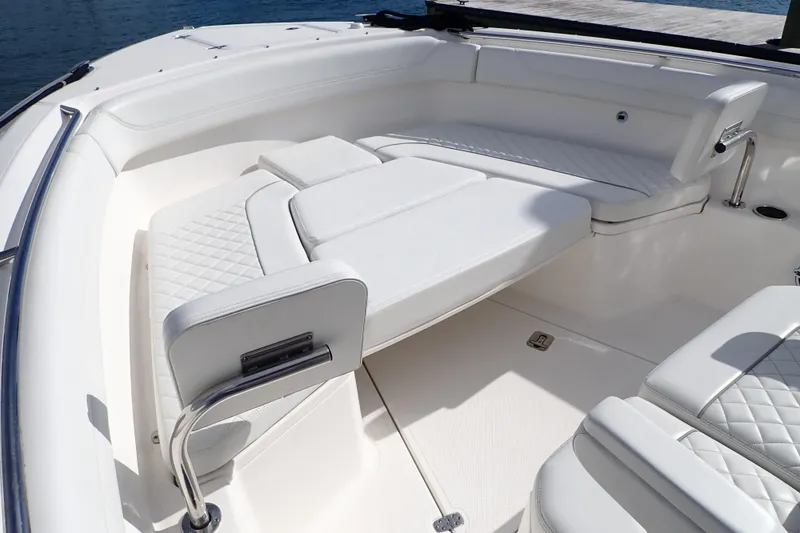 Slide: The Image of 2024 Pursuit S 288 Sport boat interior with white cushioned seating and sleek design. - 11
