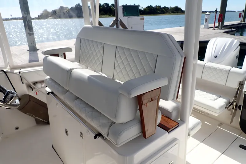 Slide: The Image of 2024 Pursuit S 288 Sport boat interior with luxurious white seating and wood accents. - 14