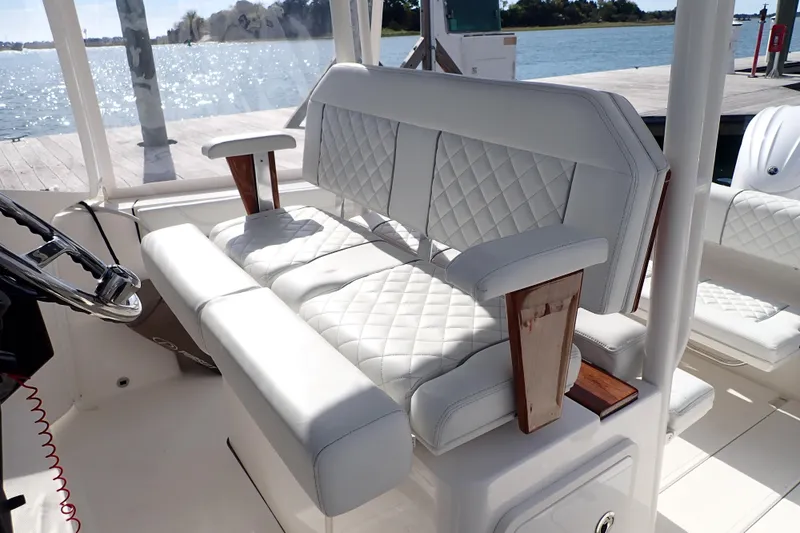 Slide: The Image of 2024 Pursuit S 288 Sport boat interior with luxurious white seating and wooden accents. - 15