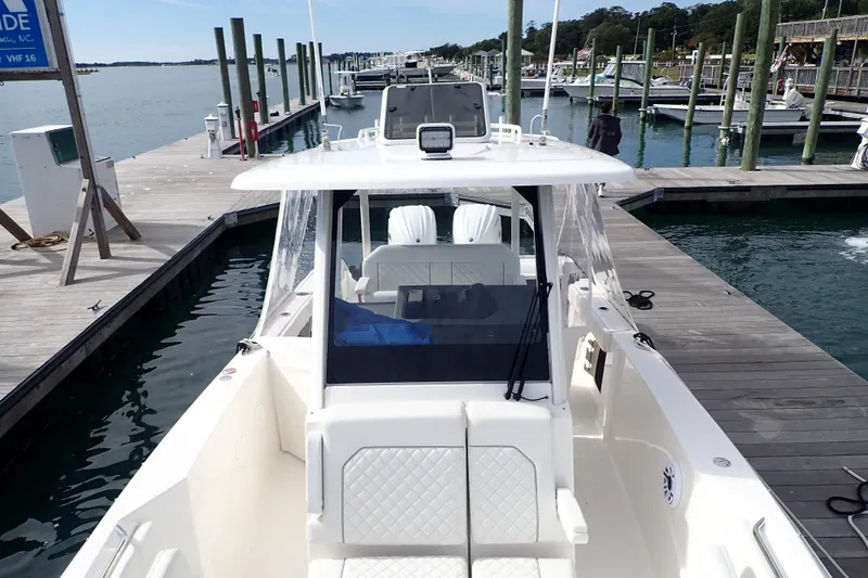 Slide: The Image of 2024 Pursuit S 288 Sport boat docked at a marina, showcasing sleek design and spacious layout. - 22