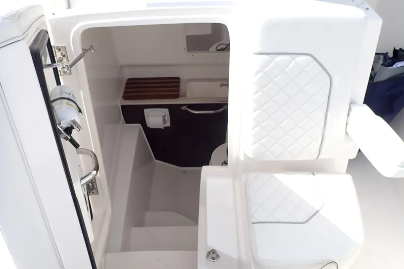Slide: The Image of 2024 Pursuit S 288 Sport boat interior with white seating and compact cabin space. - 27