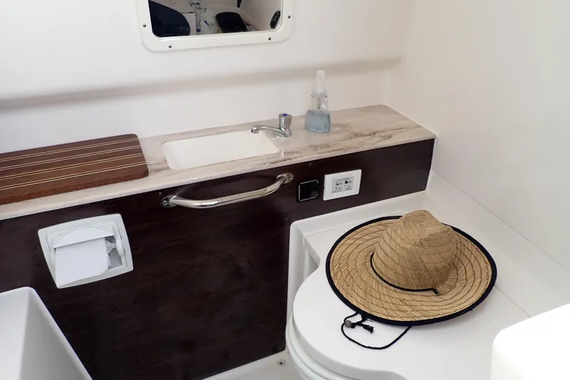 Slide: The Image of 2024 Pursuit S 288 Sport boat bathroom with sink, mirror, and straw hat. - 28
